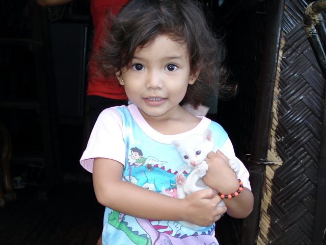 A real cutie eagerly showing off her blue eyed kitten
